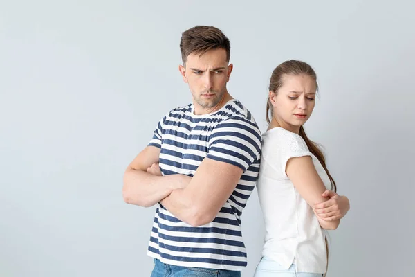 Young couple after quarrel on light background — Stock Photo, Image