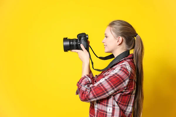 Jovem fotógrafa feminina em fundo de cor — Fotografia de Stock