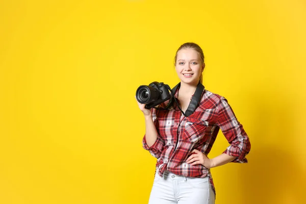 Jonge vrouwelijke fotograaf op kleur achtergrond — Stockfoto