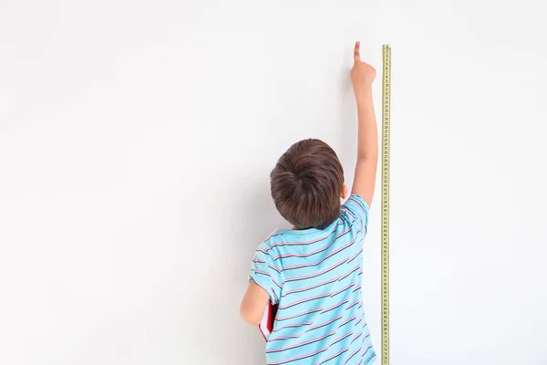 귀여운 작은 소년 벽 근처 높이 를 측정 — 스톡 사진