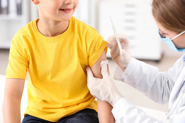 Medico vaccinare bambino in clinica — Foto Stock