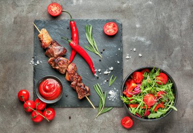 Gri arka planda sebze salatası ve sos ile lezzetli ızgara et