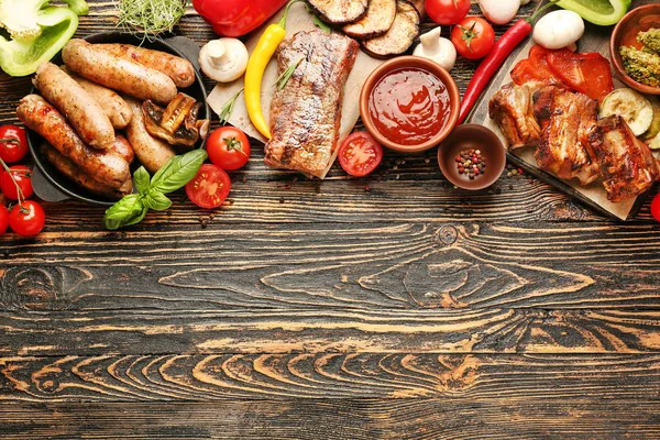 Sabrosa carne a la parrilla con salchichas y verduras sobre fondo de madera —  Fotos de Stock