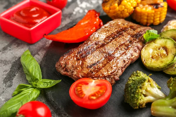 Viande et légumes grillés savoureux sur plaque d'ardoise, gros plan — Photo