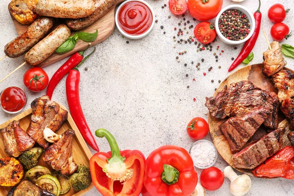 Marco hecho de sabrosa carne a la parrilla con salchichas y verduras sobre fondo gris —  Fotos de Stock