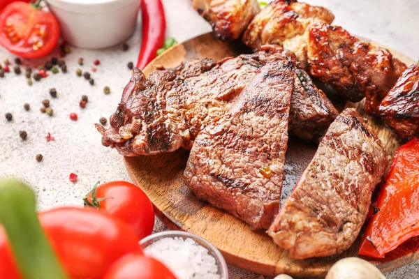 Tallrik med välsmakande grillat kött på bordet — Stockfoto