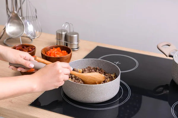 Woman cooking traditional chili con carne in kitchen — Stock Photo, Image