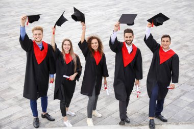 Mezuniyet gününde bekarlığa veda cübbeli mutlu öğrenciler