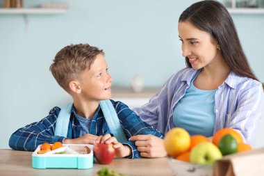 Anne ve küçük oğlu okuldan önce öğle yemeği kutusu ile