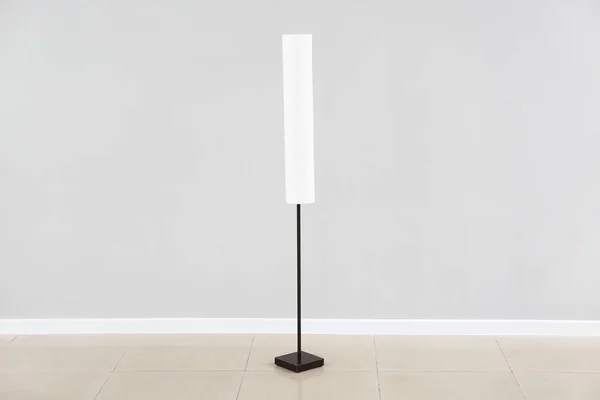 Stylish lamp near grey wall — Stock Photo, Image