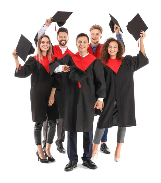 Mladí studenti v bakalářských róbách na bílém pozadí — Stock fotografie