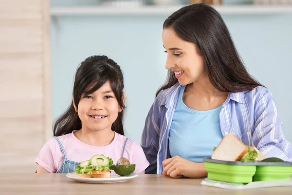 Mother and her little daughter with school lunch in morning at home — Stock Photo, Image