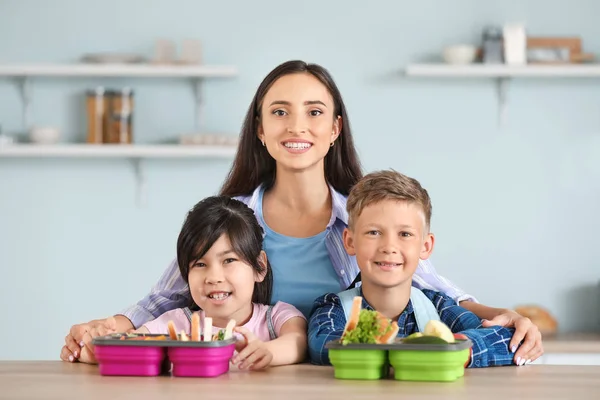 Mother and her little children with lunch boxes before school — Stock Photo, Image