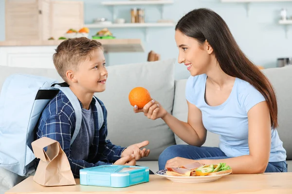 Mother packing school lunch for her little son at home — Stock Photo, Image