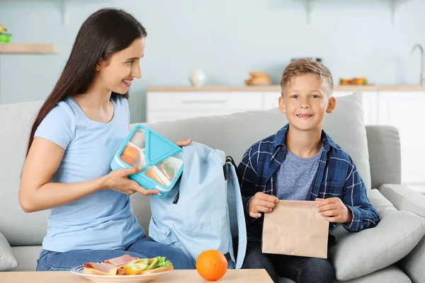 Kis fia, mielőtt iskolába hátizsákba anya üzembe ebéd-box — Stock Fotó