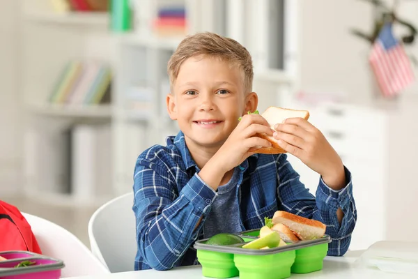 Маленький школяр їсть смачний обід у класі — стокове фото