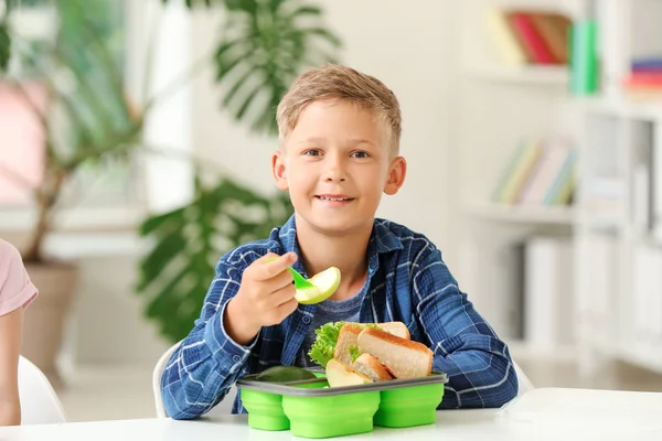 Piccolo scolaro mangiare gustoso pranzo in classe — Foto Stock