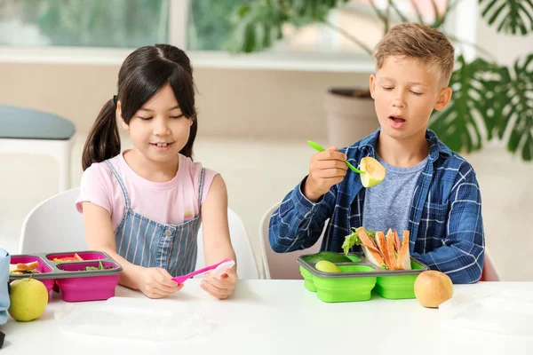 Schoolchildren having lunch in classroom — Stock Photo, Image