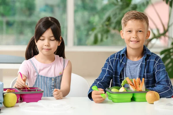 Schoolchildren having lunch in classroom — Stock Photo, Image