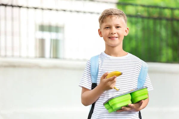 Kleine school jongen met lunch box buitenshuis — Stockfoto