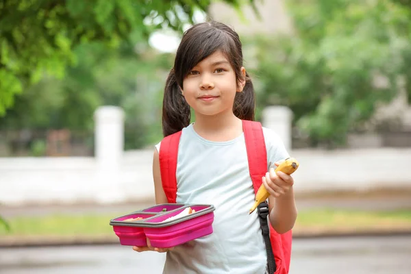 Μικρή μαθήτρια με κουτί μεσημεριανού φαγητού σε εξωτερικούς χώρους — Φωτογραφία Αρχείου
