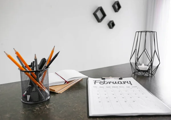 Foglio di carta con calendario e cancelleria sul tavolo dell'ufficio — Foto Stock