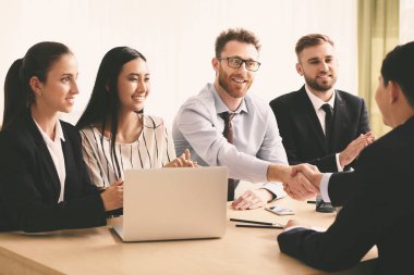 İnsan kaynakları yöneticisi başarılı bir röportajdan sonra başvuranla tokalaşıyor