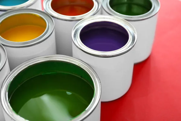 Cans of paints on color background