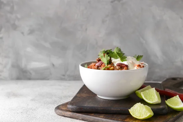 Tigela com chili saboroso con carne em fundo cinza — Fotografia de Stock