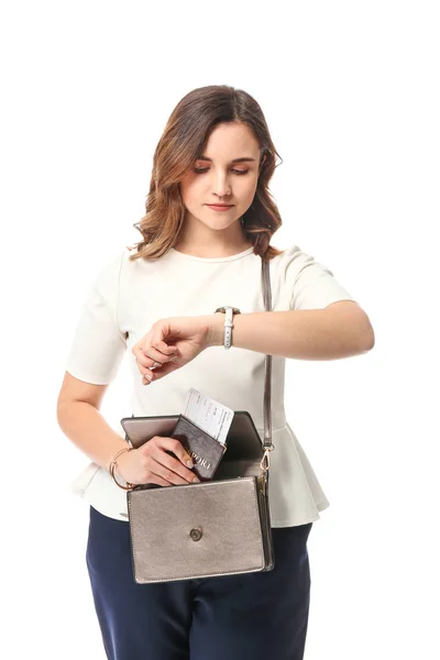 Mujer joven con documentos para viaje de negocios mirando el reloj sobre fondo blanco — Foto de Stock