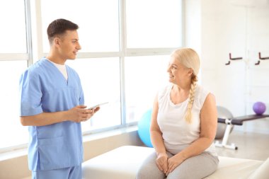 Rehabilitasyon merkezinde olgun hasta ile çalışan fizyoterapist