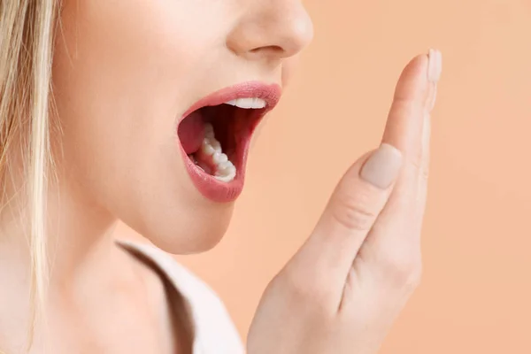 Beautiful woman checking freshness of her breath on color background, closeup — Stock Photo, Image