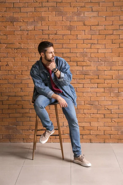 Fashionable young man near brick wall — Stock Photo, Image