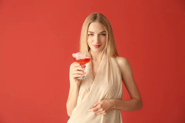 Mooie vrouw met suikerspin cocktail op kleur achtergrond — Stockfoto
