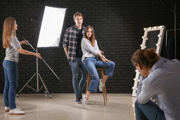 Professional photographer working with models in studio — Stock Photo, Image