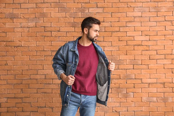 Fashionable young man near brick wall — Stock Photo, Image