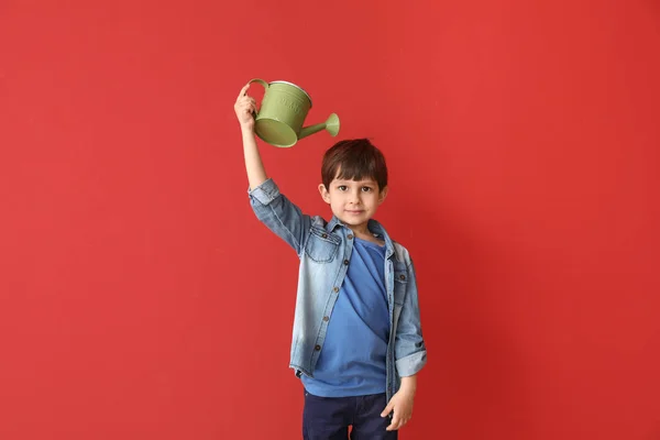 Little boy with watering can on color background. Concept of child growth — Stock Photo, Image