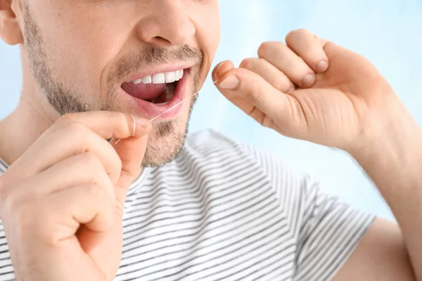 Man flossing teeth on light background, closeup Royalty Free Stock Images