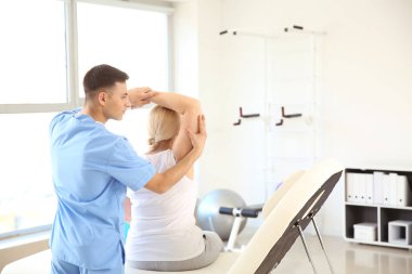 Rehabilitasyon merkezinde olgun hasta ile çalışan fizyoterapist