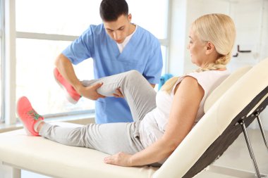 Rehabilitasyon merkezinde olgun hasta ile çalışan fizyoterapist