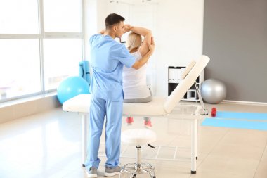 Rehabilitasyon merkezinde olgun hasta ile çalışan fizyoterapist