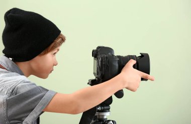 Renkli arka plan üzerinde profesyonel kamera ile sevimli küçük fotoğrafçı