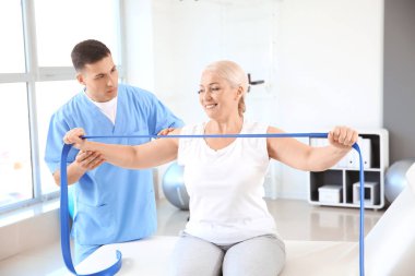 Rehabilitasyon merkezinde olgun hasta ile çalışan fizyoterapist