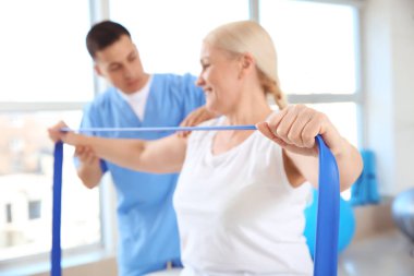 Rehabilitasyon merkezinde olgun hasta ile çalışan fizyoterapist