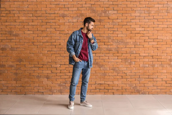 Fashionable young man near brick wall — Stock Photo, Image