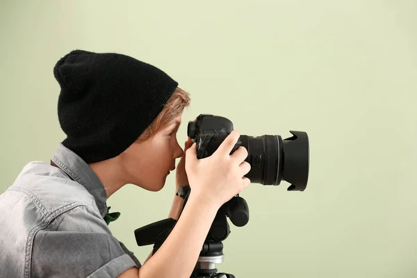Милий маленький фотограф з професійною камерою на кольоровому фоні — стокове фото
