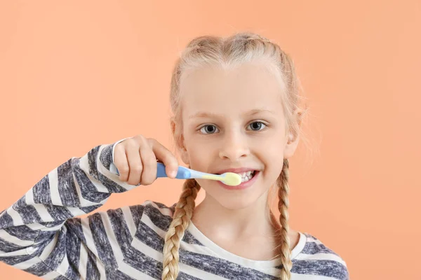 Bambina pulizia denti su sfondo di colore — Foto Stock