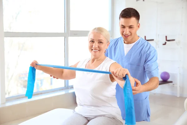 Physiotherapist working with mature patient in rehabilitation center — Stock Photo, Image
