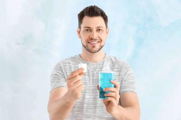 Man with mouth rinse on light background