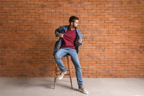 Fashionable young man near brick wall — Stock Photo, Image